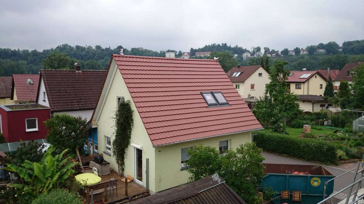 Einfamilienhaus mit neu eingedecktem roten Ziegeldach nach der Dachsanierung