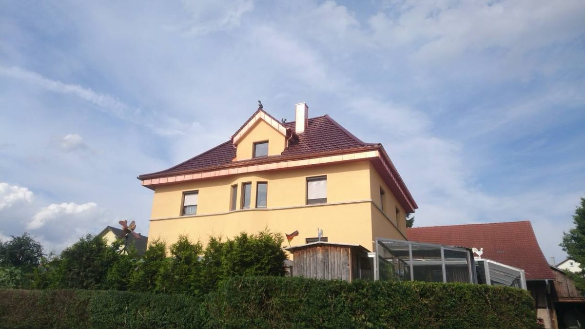 Wohnhaus mit rotem Walmdach und Kupfer-Verblechung nach der Neueindeckung