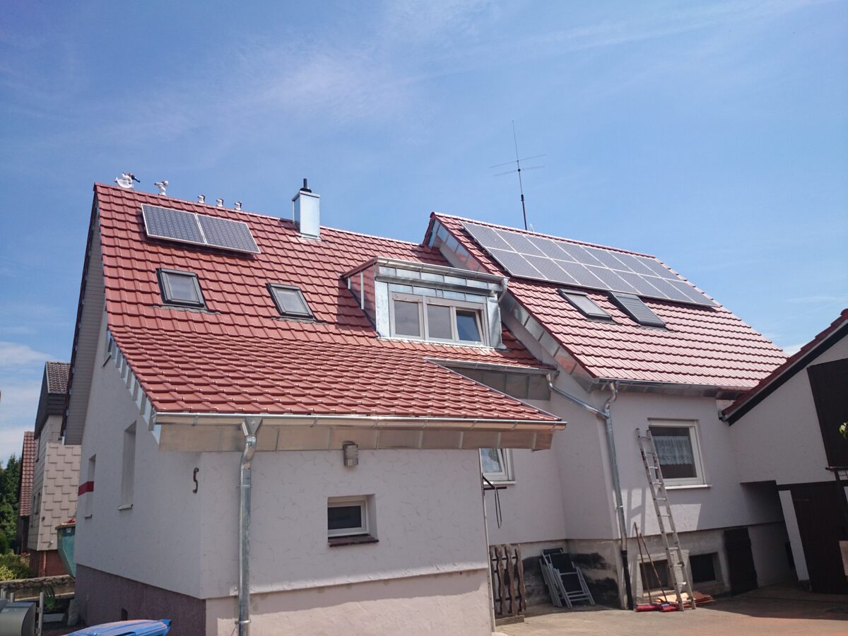 Wohnhaus mit rotem Ziegeldach, neuen Spenglerarbeiten an Rinnen und Gauben sowie Photovoltaikmodulen